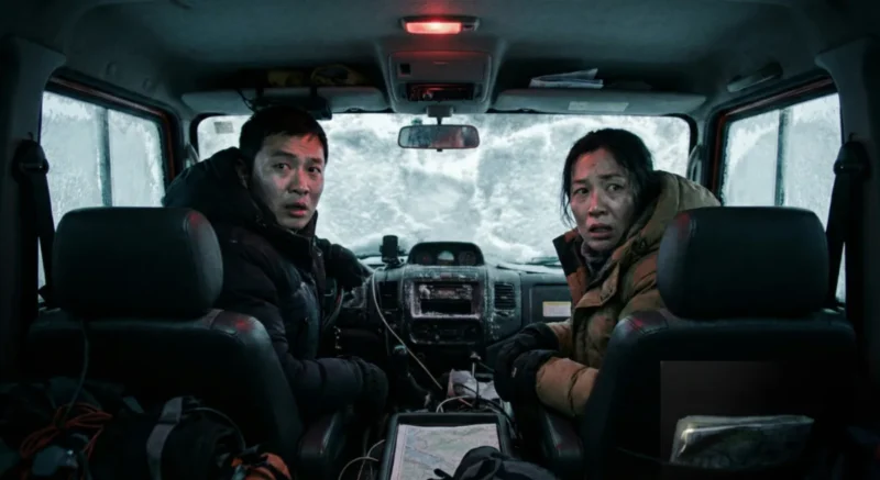 Wu Bolin dan Kohei Kikuchi berdiskusi tegang di dalam kendaraan salju mengenai kebocoran informasi.